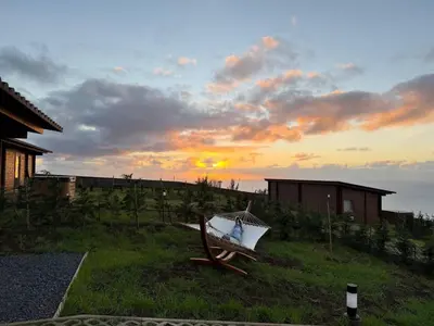 a boat sitting on the grass near a house at Sunset Eco Shelter 5 in Ponta do Pargo