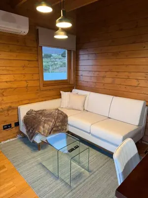 a living room with a couch and a glass table at Sunset Eco Shelter 5 in Ponta do Pargo