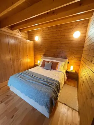 a bedroom with a bed in a wooden cabin at Sunset Eco Shelter 5 in Ponta do Pargo