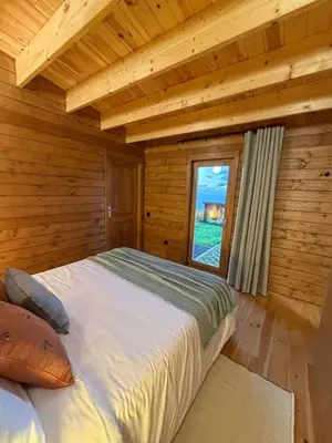 a bedroom with a bed in a wooden cabin at Sunset Eco Shelter 5 in Ponta do Pargo