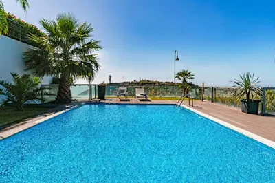 a blue swimming pool with a view of the ocean at Villa Sol e Mar Dio by Villa Plus in Caniço