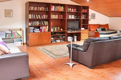 a living room with a couch and a television at Villa Sol e Mar Dio by Villa Plus in Caniço