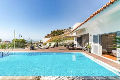a swimming pool in front of a house at Villa Sol e Mar Dio by Villa Plus in Caniço