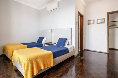 two beds with blue and yellow sheets in a room at Villa Sea Shore Dio by Villa Plus in Gaula