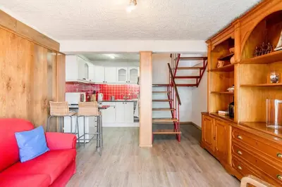 a living room with a red couch and a kitchen at Villa Sea Shore Dio by Villa Plus in Gaula
