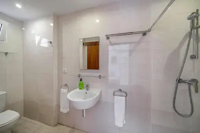a white bathroom with a sink and a shower at Villa Casa Amelia Dio by Villa Plus in Caniço