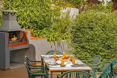 a table and chairs on a patio with a fireplace at Villa Casa Amelia Dio by Villa Plus in Caniço