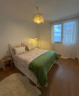 a bedroom with a bed with a green blanket and a window at Lido Sea Apart in Funchal