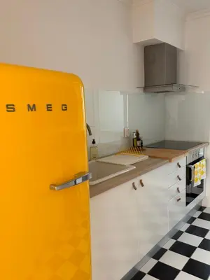 a yellow refrigerator in a kitchen with a checkered floor at Lido Sea Apart in Funchal