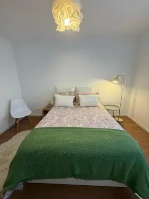 a bedroom with a bed with a green blanket on it at Lido Sea Apart in Funchal