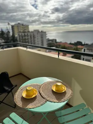 a table with two straw hats on top of a balcony at Lido Sea Apart in Funchal