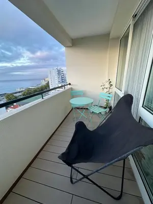 a balcony with a chair and a table on it at Lido Sea Apart in Funchal