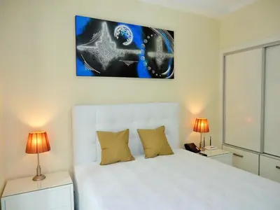 a bedroom with a white bed with two lamps at São Francisco Accommodation in Funchal
