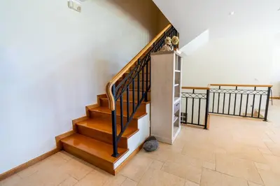 a staircase in a home with wood and white walls at Infinite Ocean View Villa 20m above Ocean & Beach in Arco da Calheta