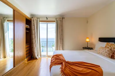 a bedroom with a bed with a view of the ocean at Infinite Ocean View Villa 20m above Ocean & Beach in Arco da Calheta
