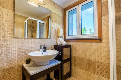 a bathroom with a sink and a mirror at Infinite Ocean View Villa 20m above Ocean & Beach in Arco da Calheta