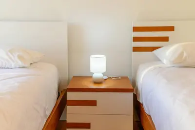 a bedroom with two beds and a lamp on a night stand at Assomada Sea Pearl by Mth in Caniço