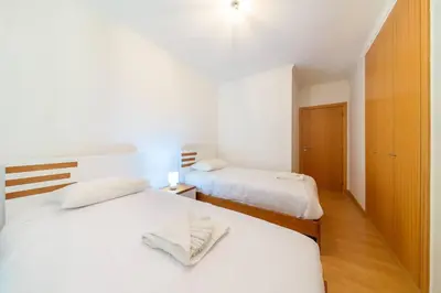 two beds in a bedroom with white sheets at Assomada Sea Pearl by Mth in Caniço