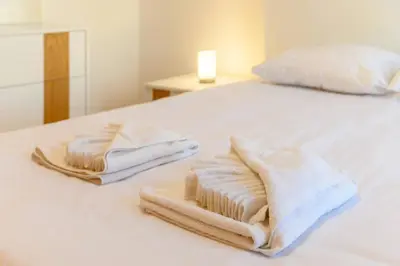 two towels are sitting on a white bed at Assomada Sea Pearl by Mth in Caniço