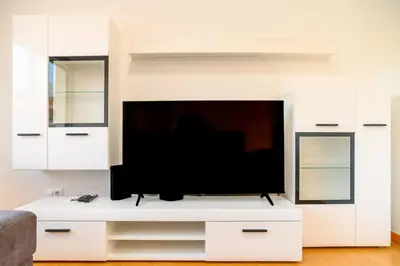 a living room with a flat screen tv on a white entertainment center at Assomada Sea Pearl by Mth in Caniço