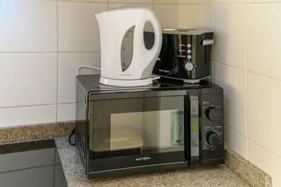 a microwave with a coffee maker on top of it at Assomada Sea Pearl by Mth in Caniço