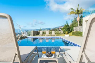 a patio with a table and chairs next to a swimming pool at Eco Monte by Atlantic Holiday in Funchal