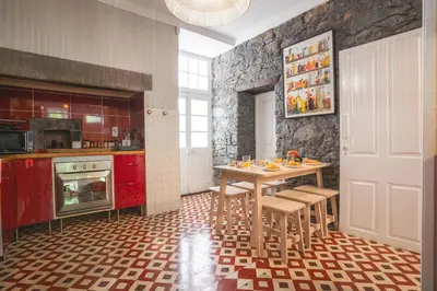 a kitchen with a table and chairs in a room at Casa dos Francelhos by Atlantic Holiday in Funchal