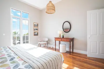 a bedroom with a bed and a desk and a mirror at Casa dos Francelhos by Atlantic Holiday in Funchal