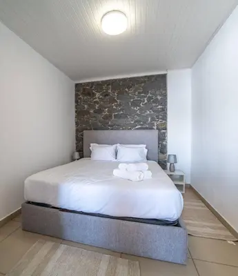 a living room with a couch and a table and windows at Atouguia Villa in Calheta