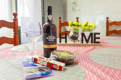 a bottle of wine and a glass on a table at Estrela House I Calheta Madeira in Calheta