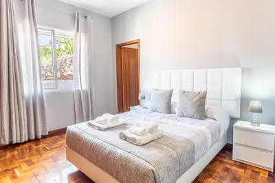 a bedroom with a white bed with two towels on it at Estrela House I Calheta Madeira in Calheta