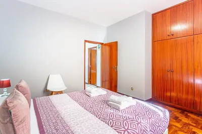 a bedroom with a bed and a wooden cabinet at Estrela House I Calheta Madeira in Calheta