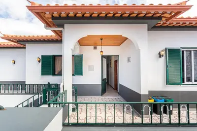 a house with green shutters and a porch at Estrela House I Calheta Madeira in Calheta