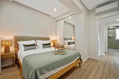a bedroom with a large bed with a table on it at Modern Flat Just Steps From Shore in Ponta do Sol