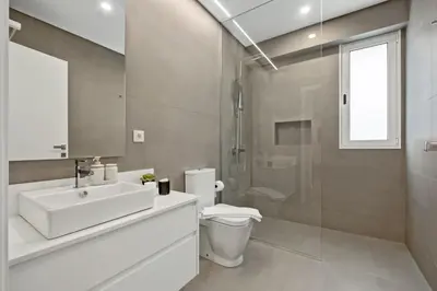 a bathroom with a sink and a toilet and a shower at Modern Flat Just Steps From Shore in Ponta do Sol