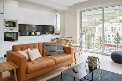 a living room with a couch and a table at Modern Flat Just Steps From Shore in Ponta do Sol
