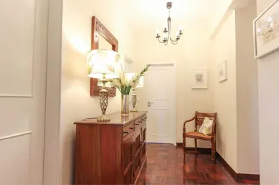 a hallway with a dresser with a lamp and flowers on it at City Centre - Savoy District Funchal in Funchal