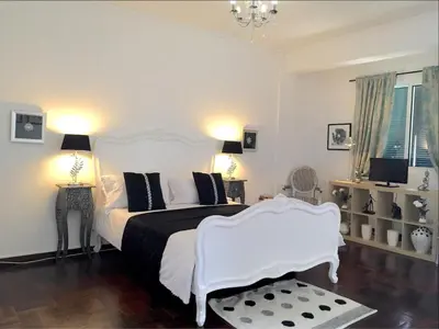 a bedroom with a white bed and a white chair at City Centre - Savoy District Funchal in Funchal