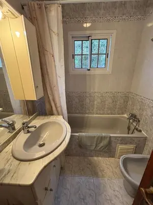 a bathroom with a sink and a tub at Panoramic Funchal View - 3BR Two-Storey Home in Funchal