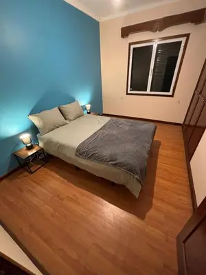 a bedroom with a bed with a blue wall at Panoramic Funchal View - 3BR Two-Storey Home in Funchal