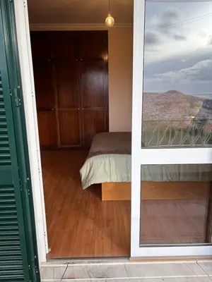 a bedroom with a bed and a view from a door at Panoramic Funchal View - 3BR Two-Storey Home in Funchal