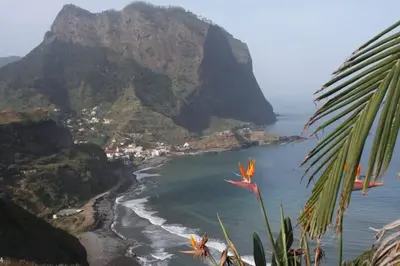 a view of a beach with a mountain in the background at Villa da Rochinha - Luxusapartment mit Atlantikblick in São Roque do Faial