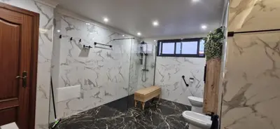 a bathroom with a toilet and a glass shower at Villa da Rochinha - Luxusapartment mit Atlantikblick in São Roque do Faial