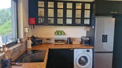 a kitchen with a refrigerator and a washing machine at Villa da Rochinha - Luxusapartment mit Atlantikblick in São Roque do Faial