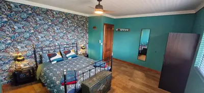 a bedroom with a bed and a blue wall at Villa da Rochinha - Luxusapartment mit Atlantikblick in São Roque do Faial