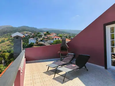 a balcony with two chairs and a stove on it at Da Flat in Calheta