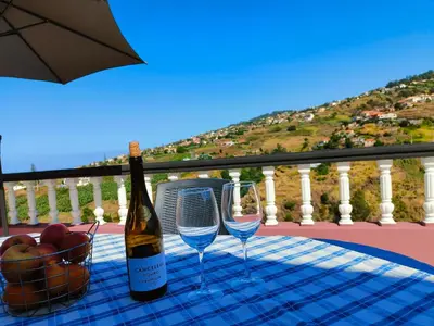 a bottle of wine and two glasses on a table at Da Flat in Calheta