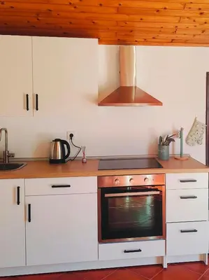 a kitchen with white cabinets and a stove top oven at Da Flat in Calheta