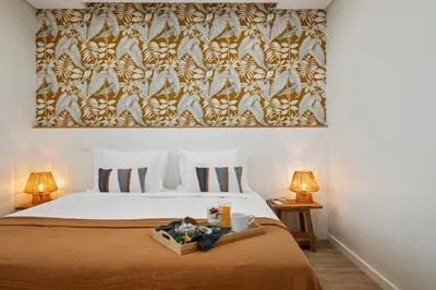 a bedroom with a bed with a blanket and two lamps at Modern Apartment Steps From Beach in Ponta do Sol