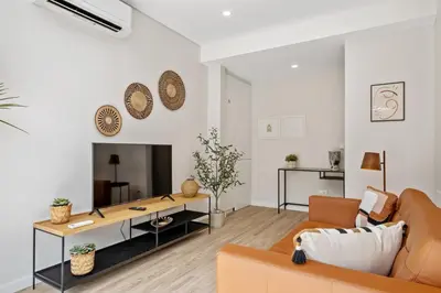 a living room with a couch and a table at Modern Apartment Steps From Beach in Ponta do Sol
